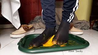 Male Feet Cushing A Fruit In Worn-Out Sheer Socks
