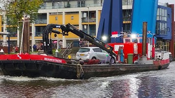 Tug MERWESTREEK from Belgium. Work vessel. Old barge with a crane. The ship passes the Dutch bridge.