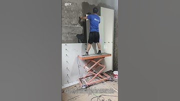 Giant Tile Mastery: Craftsman Uses Electric Lift for Flawless Wall Installation!