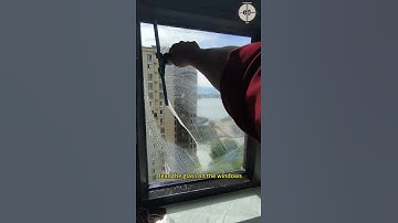Workers use rubber scrapers to clean the glass on the windows