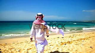 Man In Traditional Middle Eastern Clothing Walking On Beach Visustock