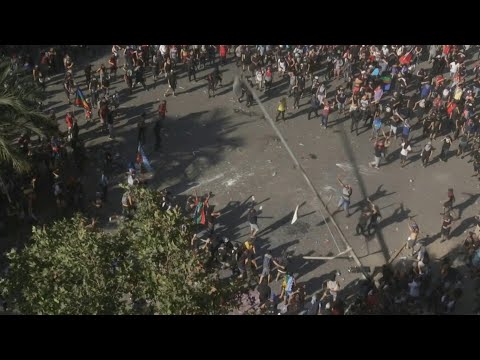 AFP: Chili: manifestation massive à Santiago où des manifestants font tomber un lampadaire | AFP Images AFP: Chili: manifestation massive à Santiago où des manifestants font tomber un lampadaire | AFP Images