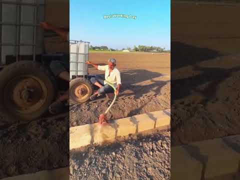 The process of watering a brick wall with a water solution using a tractor