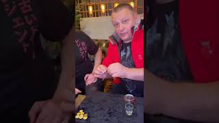 Magician Causes a Marked Coin To Reappear Inside a Covered Shot Glass