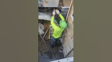 Workers install rebar in manhole for concrete wall