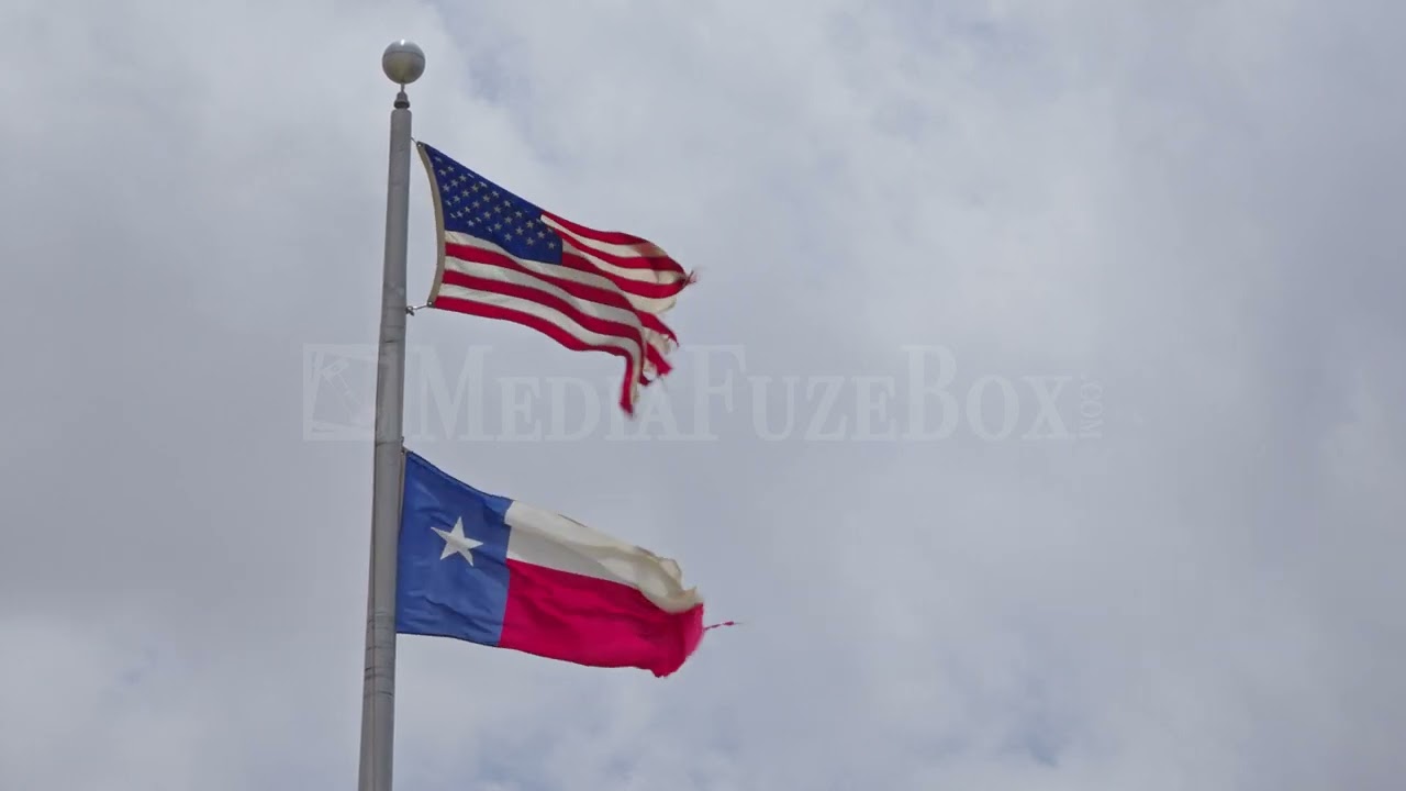 Stock Video - American and Texas Flags flying together waving in the wind