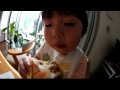 レンズを目の前に向けられても気にせずハンバーガーを食べる2歳児