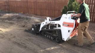 Leveling topsoil with land plane, mini skid