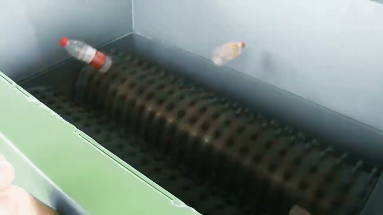 Bouteilles PET entrant dans les rouleaux dentés du perforateur