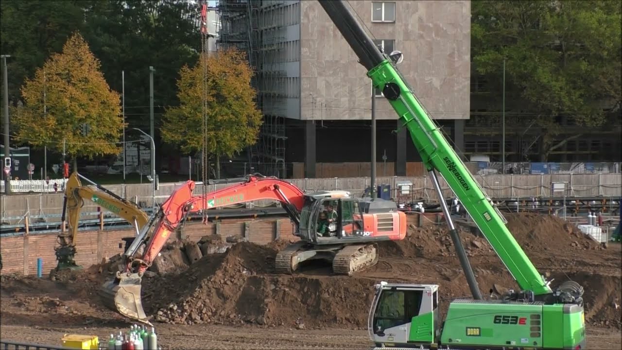 Bagger Hitachi lädt LKW, weiter auf der Großbaustelle