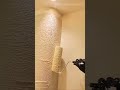 Applying a textured plaster finish to a wall with a roller for interior building renovation