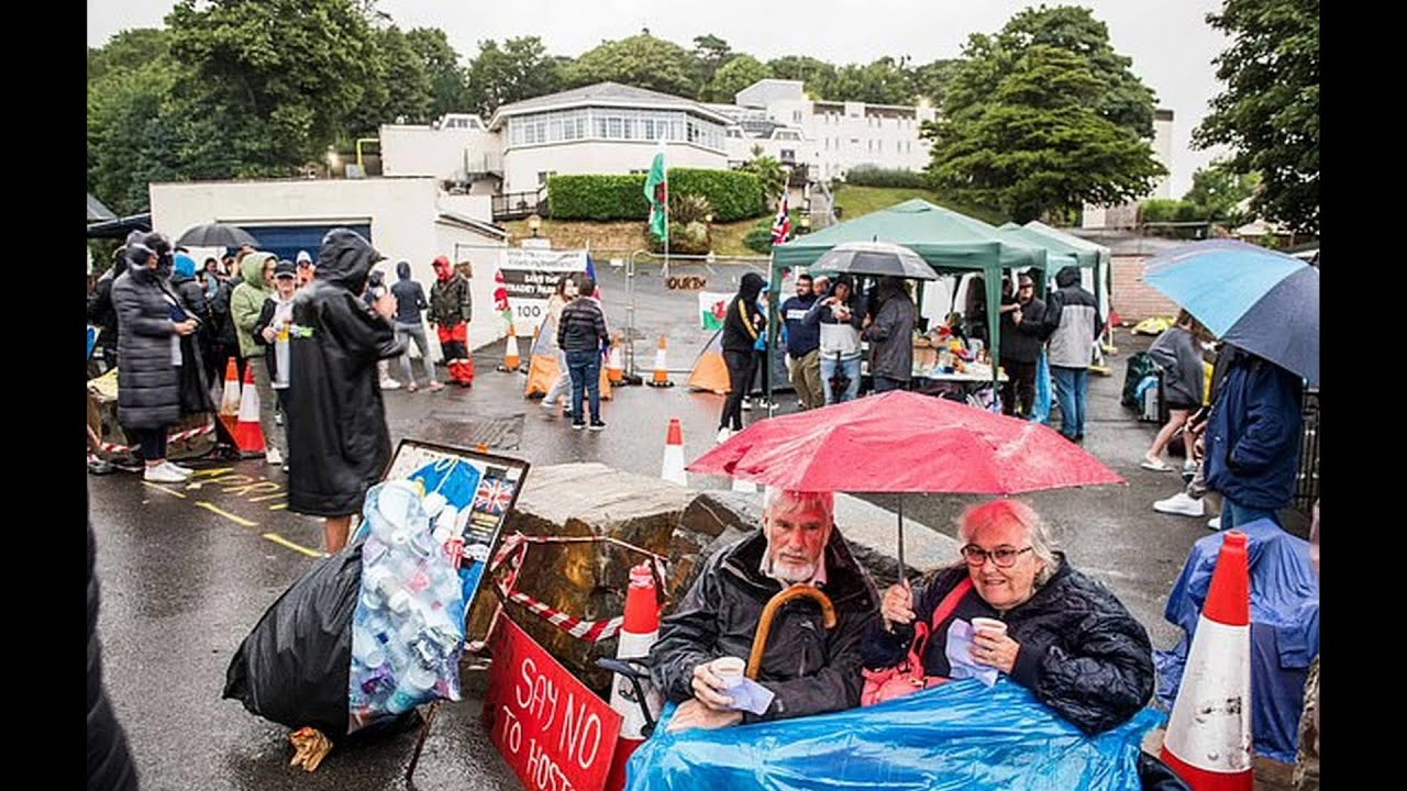 Protesters outside Stradey Park Hotel in Llanelli cheer when security leave premises