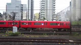 たくさんの真っ赤な名鉄車両が留置線に停泊している金山駅に到着する中央本線下り211系の車窓