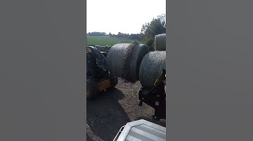Unloading round bales of hay