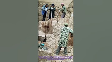 Rock Breaking with Steel Bars: Team Using Pry Tools on Stone