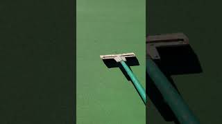 scraping off high spots and debris while tennis court resurfacing