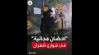 امرأتان تتحديان القيود.. وتعانقان المارة في شوارع طهران