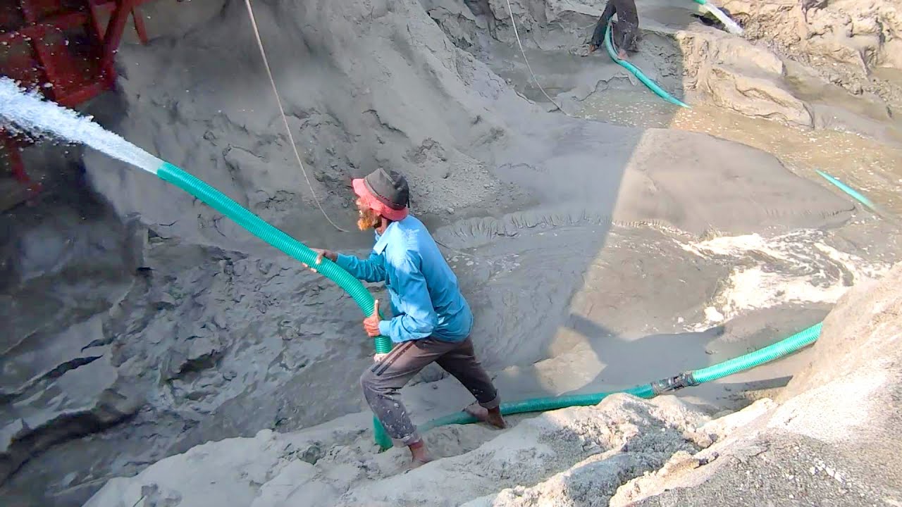 Raw Power of Water: Skilled Worker Battles High-Pressure Hose in Hydraulic Sand Mining