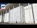Workers cover the Kennedy Center signage before removing Trump's name