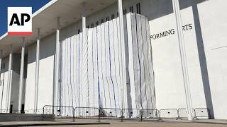 Workers cover the Kennedy Center signage before removing Trump's name