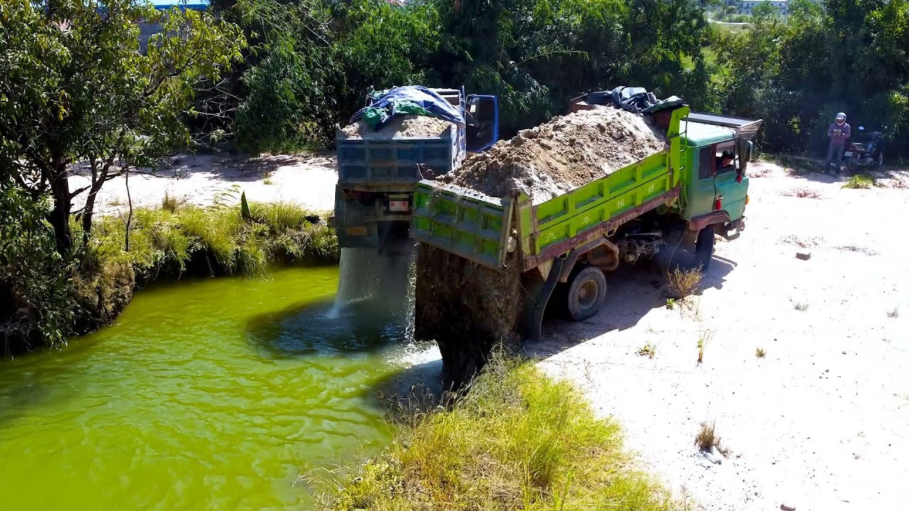 Dump truck unload soil for delete the pond