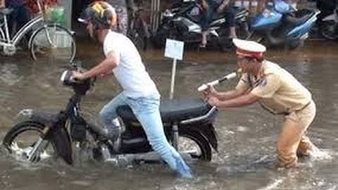 Người dân TP.HCM bì bõm lội nước sau mưa giông
