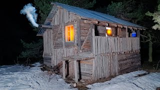 The man repairs the wooden hut he abandoned 10 years ago and hides in it