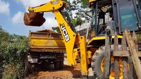 Jcb 3dx super  digging and loading soil into a dump truck