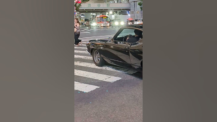 A Luxury Black Classic Car passing through Shibuya. Tokyo, Japan