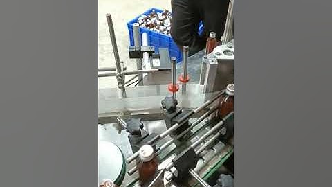 Automatic cap fitting and Automatic labeling machine on round bottle.