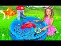 Sasha catches fish with fishing water toys