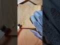 Carving patterns on a wooden surface with a special tool while wearing protective gloves carefully