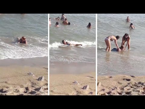 Old Women Stuck In Tiny Waves On Beach