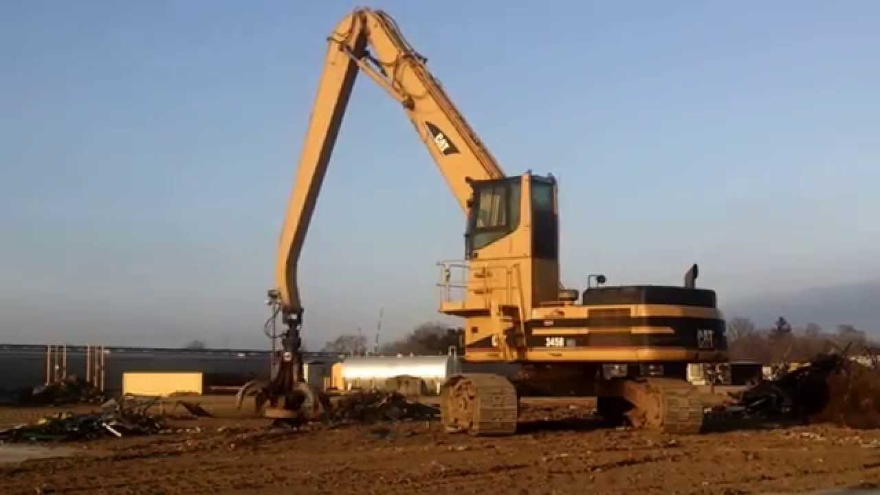 Caterpillar scrap yard crane in action. Steel Dynamics, Ticker STLD