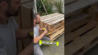 Er stellt einen Tisch mit Paletten her Er stellt einen Tisch mit Paletten her