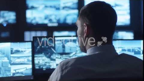 Security Officer is Drinking Coffee while Working on Computer in a Dark | VideoHive 14742400