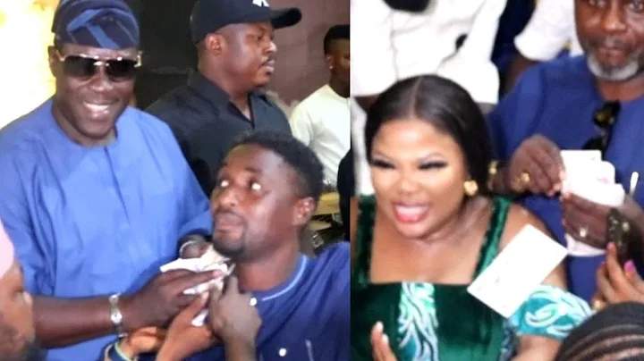 SEYI EDUN JUMPS AS TAIWO HASSAN OGOGO RAIN MONEY ON HER AND NIYI JOHNSON AT THEIR TWINS NAMING