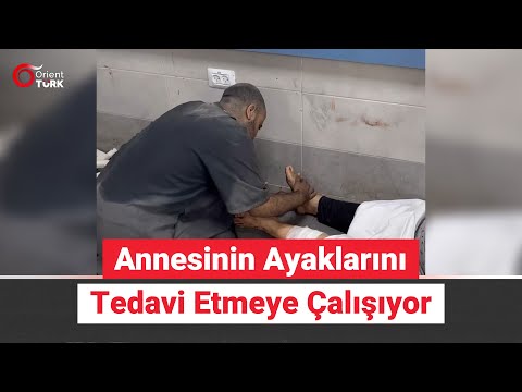 Filistinli genç, yaralanan annesinin ayaklarını tedavi etmeye çalışıyor