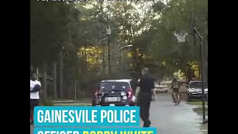 Basketball legend Shaq O'Neal and police officers play basketball with street youngsters.