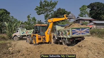 Jcb leveling land and loading soil in heavy truck