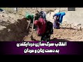 زنان و مردان باهم برای بازسازی سرک دایکندی غزنی بیل می زنند