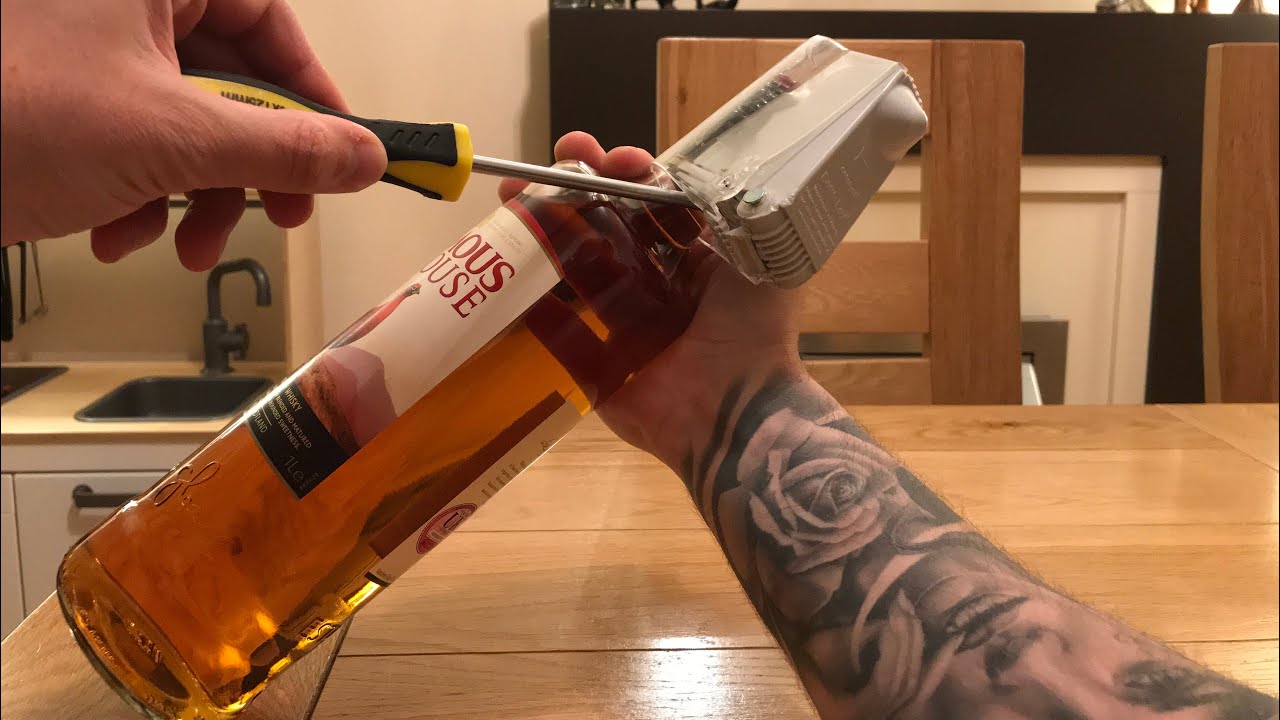 Remove (BottleLox) security device from bottle using a screwdriver 