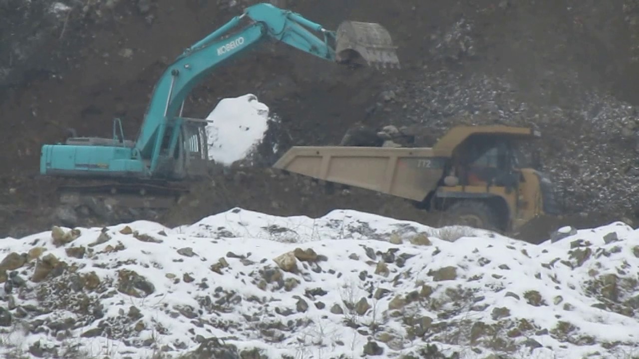 Kobelco Bagger belädt eine Caterpillar Mulde 772F