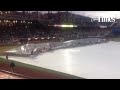 Ground crew members gather a giant tarp at the end of a rain delay  Tuesday during the Chihuahuas/Sa