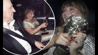 Lorraine Kelly proudly shows off her BAFTA TV gong as she heads home with her rarely seen husband