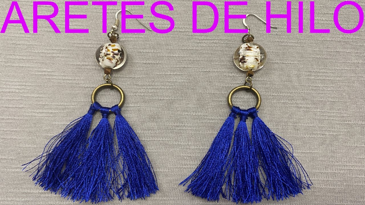 Aretes de borlas con flecos hechos de hilos de colores y cuentas fondo  blanco ia generativa