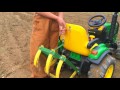 Farm Kid Driving Modified John Deere Toy Tractor With Cultivating Tines In The Garden