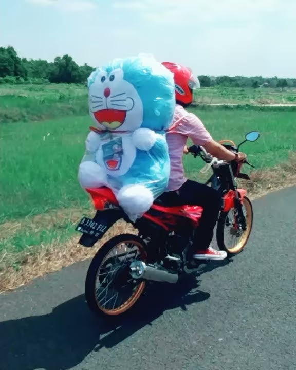 Romantis seorang cowok gonceng boneka doraemon di jalanan