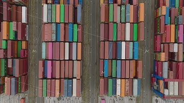 Fly above logistic site in harbour. Birds eye shot of naval cargo containers stacked in rows