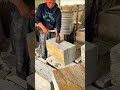 Splitting a thick stone block with a hammer and a wide chisel for architectural construction work